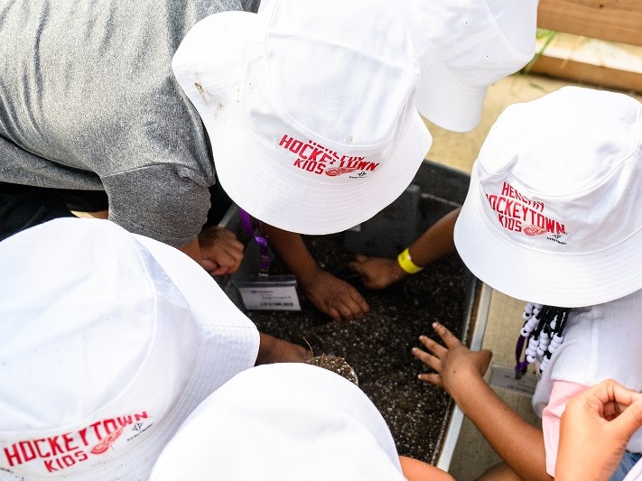 Little kids wearing HockeyTown/Trinity Health hats