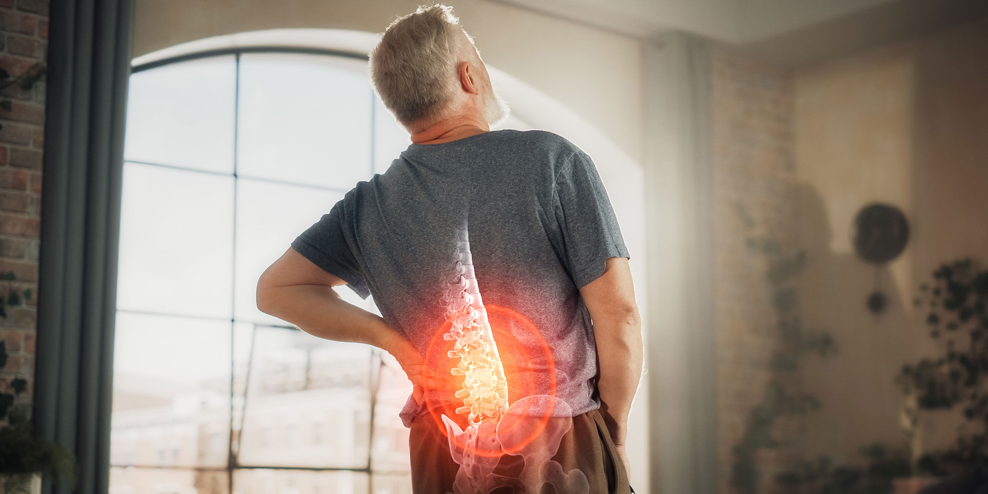 man holding spine in pain