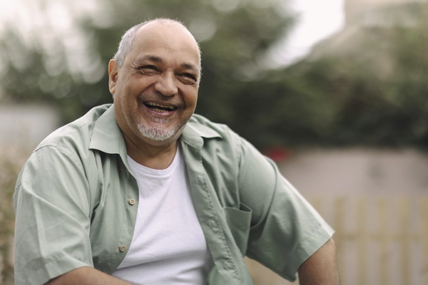 A middle-aged man grins outside